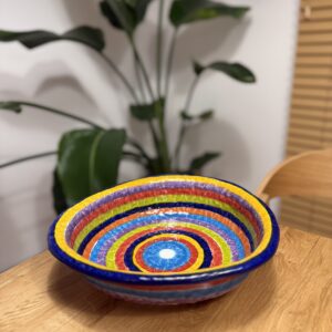 Ręcznie malowana misa ceramiczna w kolorowe pasy w domowej aranżacji